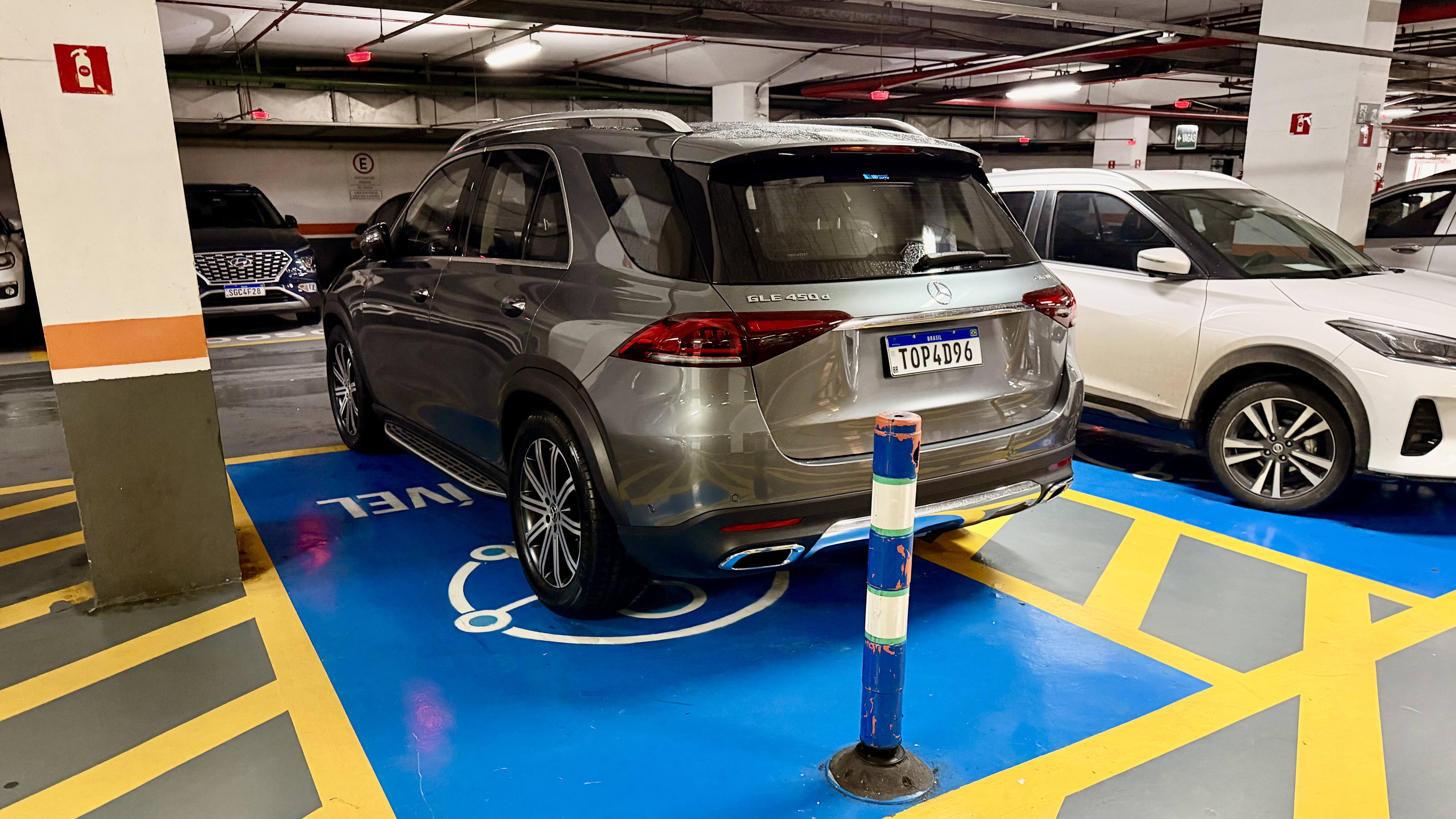 Mercedes estacionada em faixa reservada para pessoa com deficiência.